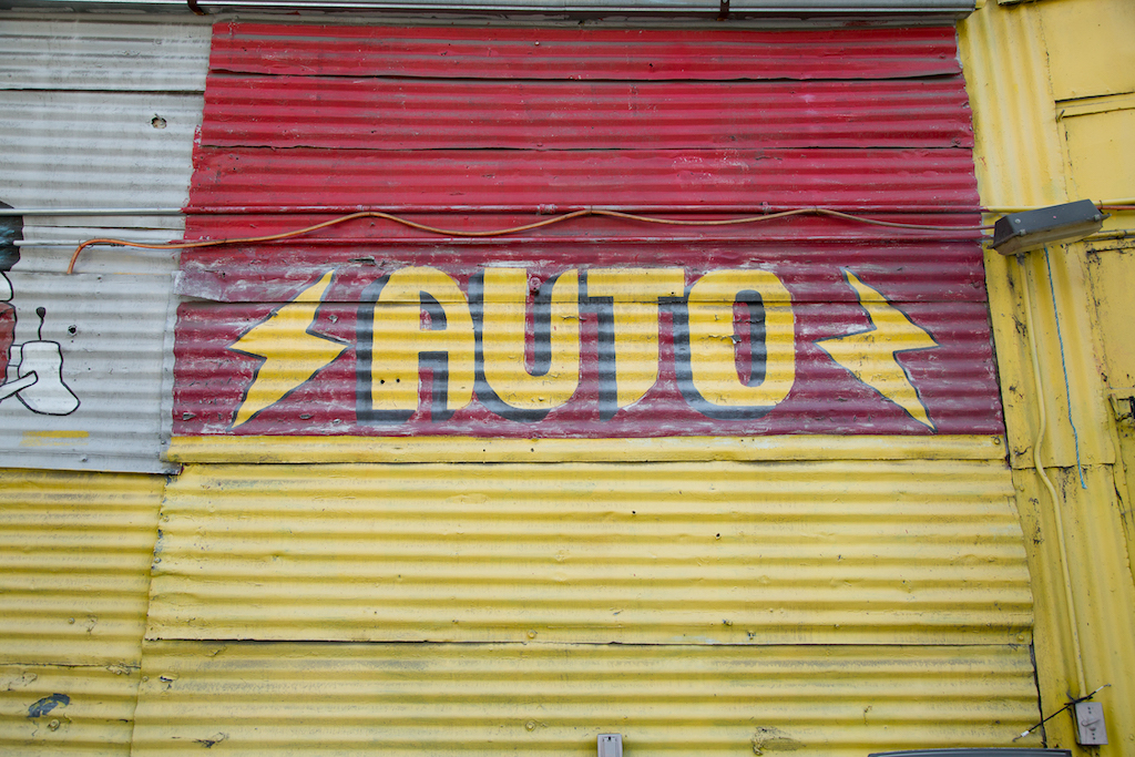 Painting on corrugated metal reflects a sign painter’s steady hand at the Cesar Chavez Body Shop, 1400 Cesar E. Chavez Avenue in East Los Angeles.