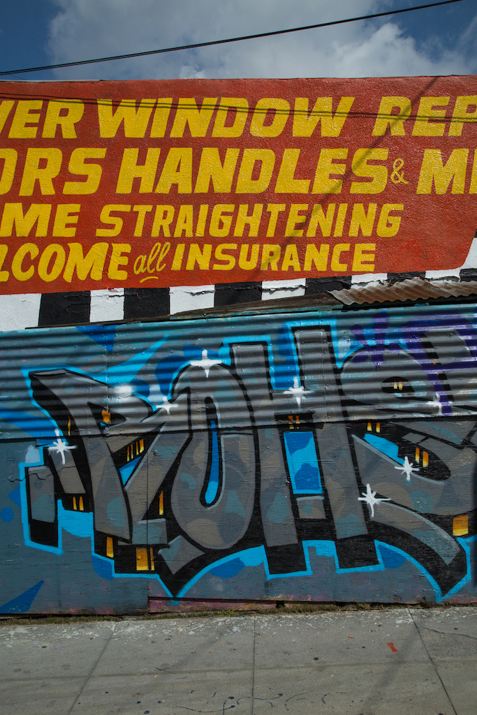 Some sign painters start as taggers. Here, an example of the work of both stand side by side at Cesar Chavez Body Shop, 1400 Cesar E. Chavez Avenue in East Los Angeles.