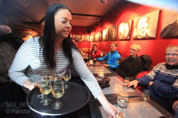 Barmaid serves patrons in Karlsberger Pub in Longyearbyen, Svalbard, Norway.