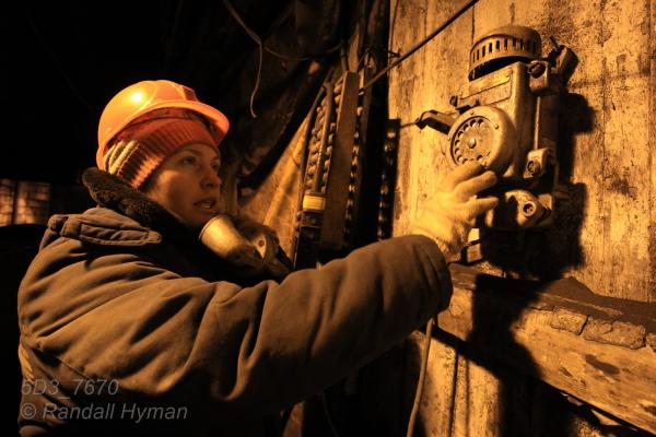 Female mine worker uses cast-metal phone in mine at Barentsburg, Svalbard, Norway.