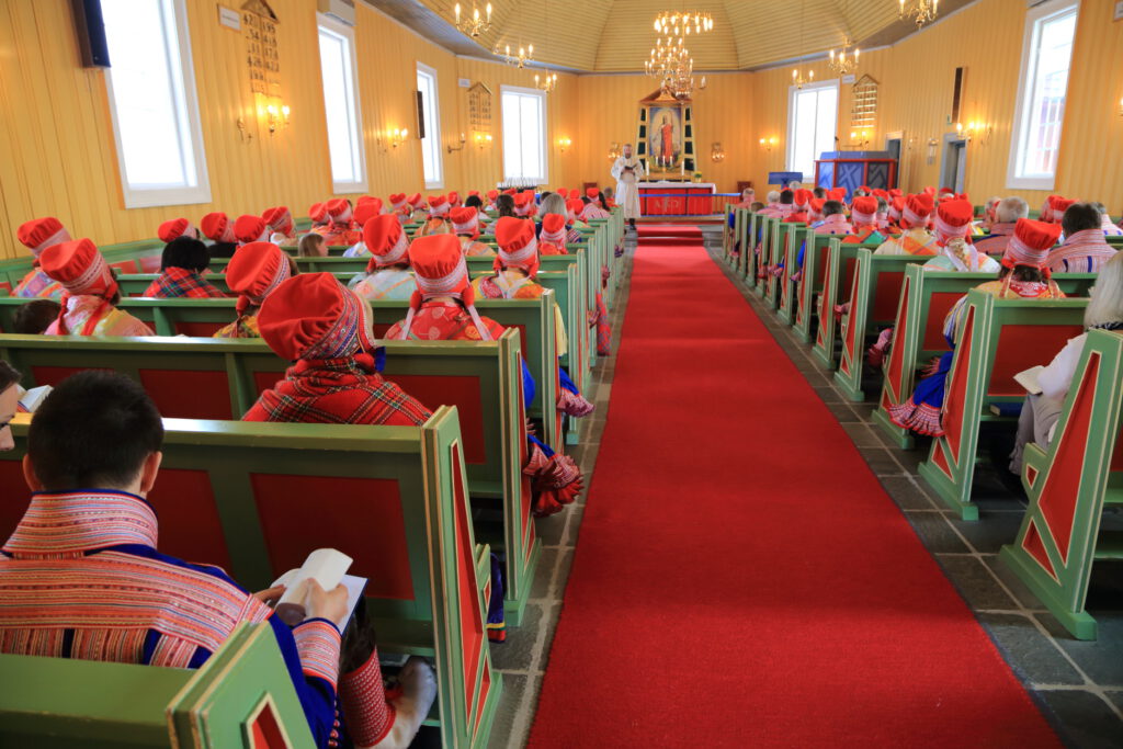 Sami congregation in festive folk attire fills main Lutheran church on Easter 2015 morning in town of Kautokeino, Finnmark, Norway.