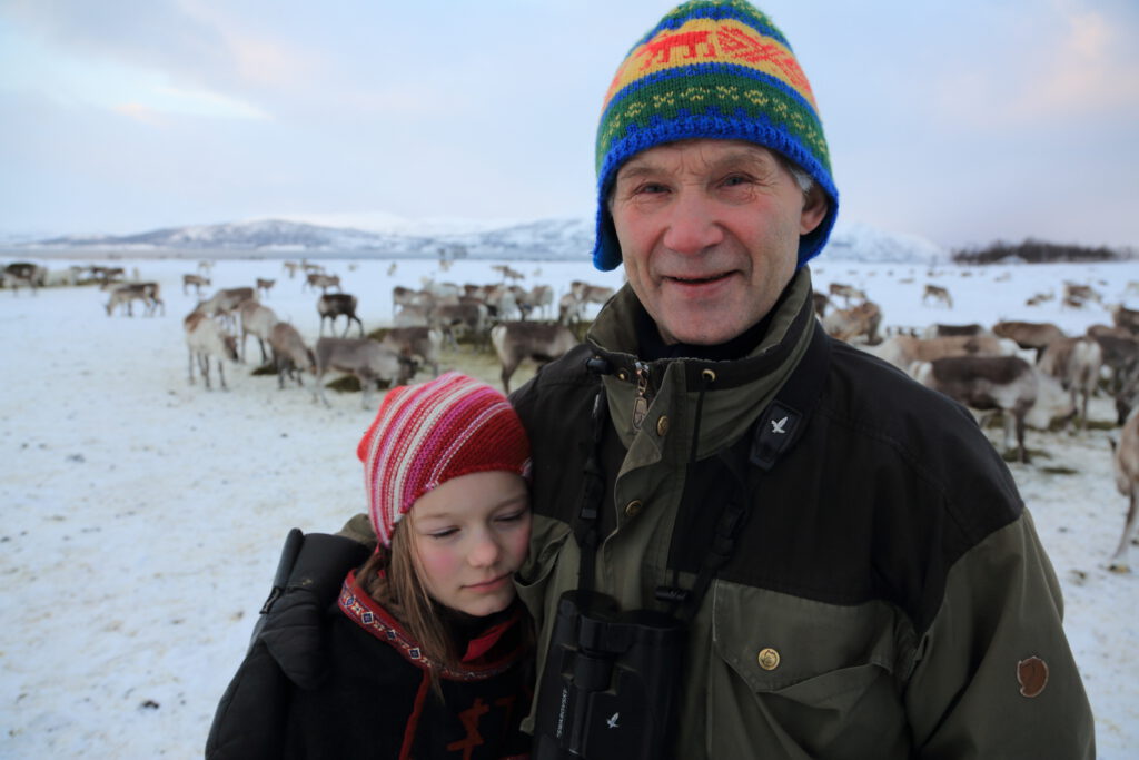 Reindeer herder Isak Tore Oskal pauses to comfort his seven-year-old girl, Eline Oskal, as they round up reindeer in icy pasture near Tromsø in January 2015.