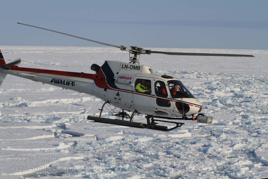 Airlift helicopter, contracted by Norwegian Polar Institute, flies over frozen Arctic Ocean in April ferrying scientists on various missions launched from the Norwegian coast guard icebreaker K/V Svalbard.