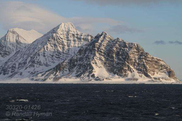 Snow-mantled mountains crown the northern tip of Prins Karls Forlandet in April in the Svalbard archipelago, Norway.
