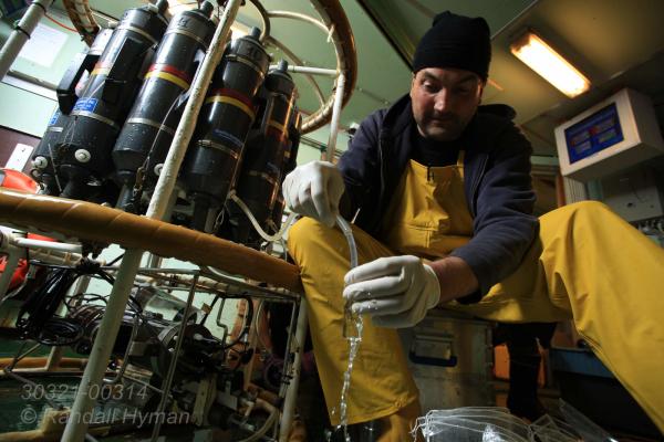 Biochemist Helge Neimann drains water sample from rosette carousel aboard R/V Helmer Hanssen to analyze microbial methane consumption during CAGE research cruise in Arctic Ocean; Svalbard archipelago, Norway.