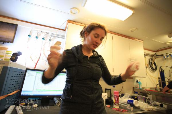 Carolyn Graves shakes bottles to produce bulbbles and use gas chromatography to analyze methane and carbon dioxide content of water samples during CAGE research cruise; Svalbard archipelago, Norway.