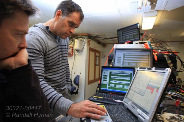 Scientists prepare cavity ring-down spectrometer (CRDS) experiment measuring methane and carbon dioxide content of surface water and air during CAGE research cruise aboard R/V Helmer Hanssen; Svalbard, Norway.