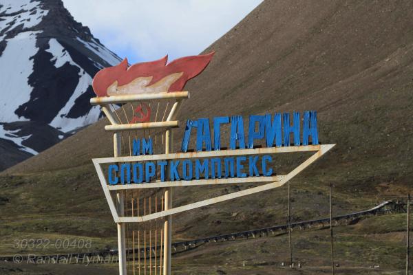 Gagarin Sports Complex sign towers above stark landscape at Pyramiden, the once-flourishing Russian coal mining town abandoned in 1998 at Isfjorden on Spitsbergen island, Svalbard archipelago, Norway.