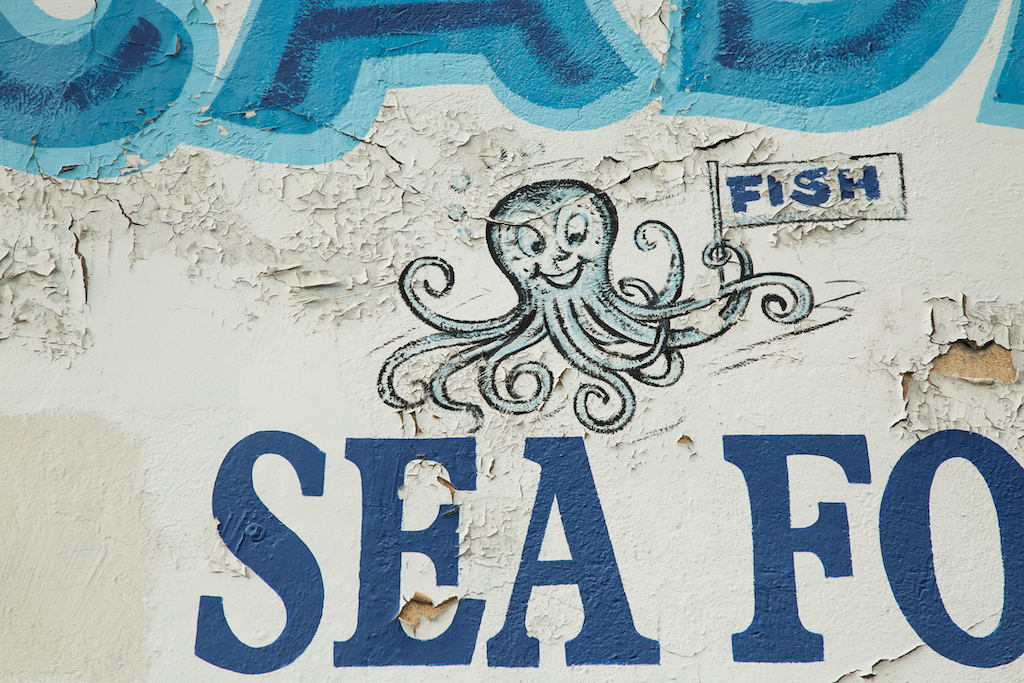 A smiling octopus holds a sign hawking “FISH” at Pescaderia, 5407 S. Central Avenue.