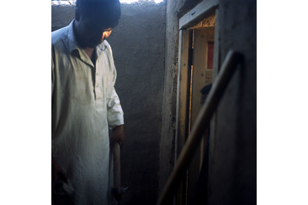 A man, displaced from Helmand, builds a home in one of the several displacement camps in Kabul.