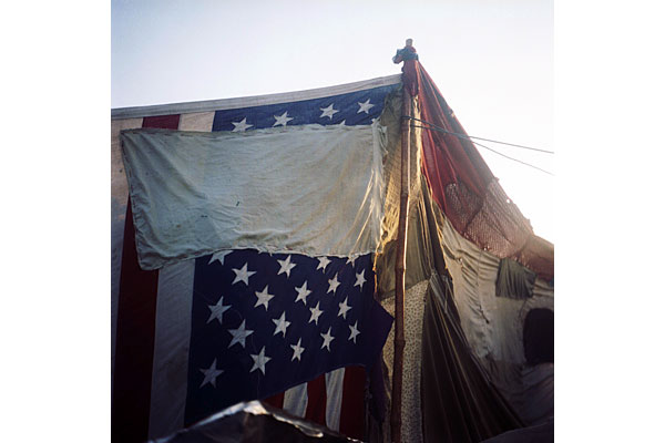 An American flag is sewn into the tent where displaced Afghans live.