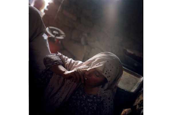 A widow lives in a mud hut with several other widows in a displacement camp in Kabul.