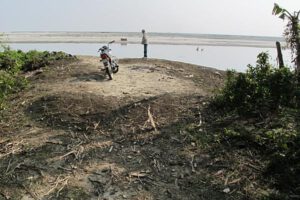 The former road to Majuli's ferry dock, now washed away. The line of trees on the horizon marks the previous location of the dock.