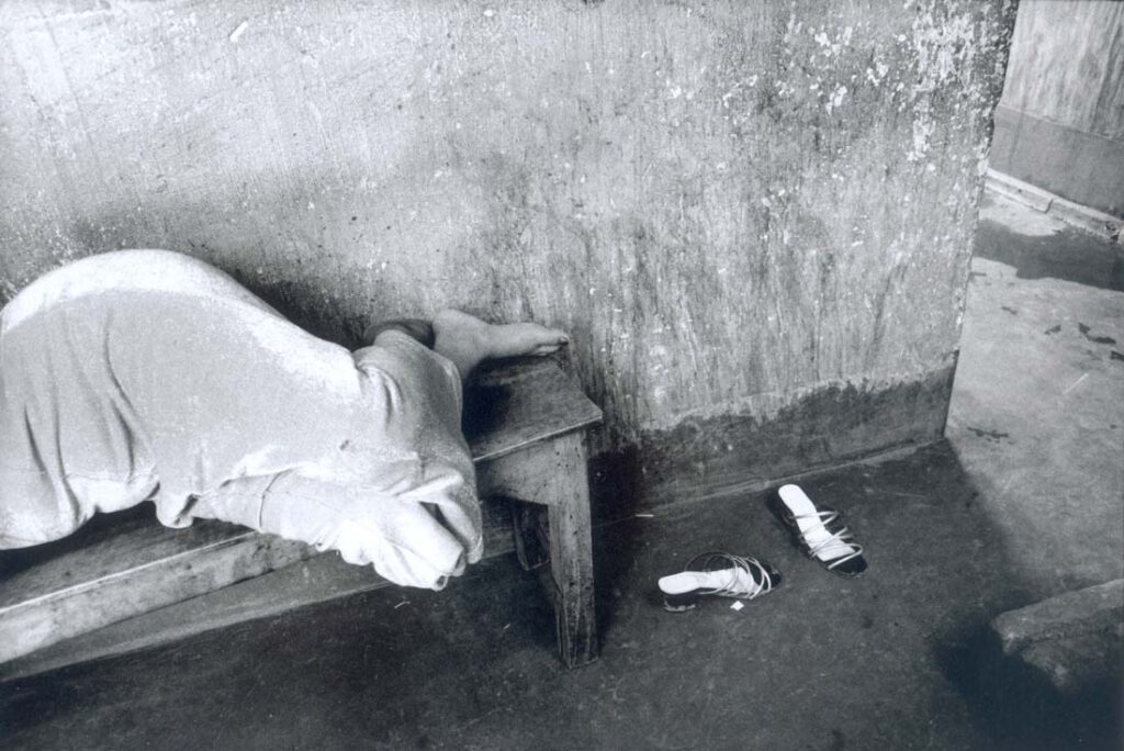 A sex worker takes an afternoon nap on a bench in the corridor. 2001 © Zana BRISKI