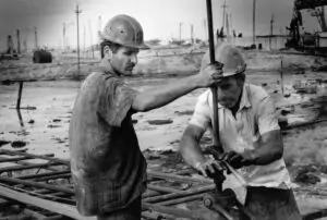 Oil workers putting a tap.