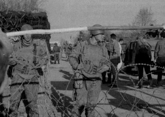 Russian soldiers of the NATO peacekeeping unit stand behind a barbed-wire barricade, blocking Muslim villagers who want to return to their prewar homes in Serb-held territory.