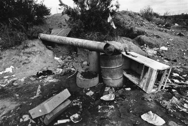 A man drinks from a water pipe in Nogales, Sonora. The pipe, which emerged from underneath the city dump, supplied all the washing and drinking water for inhabitants of this colonia. Photos by Jeffry D. Scott