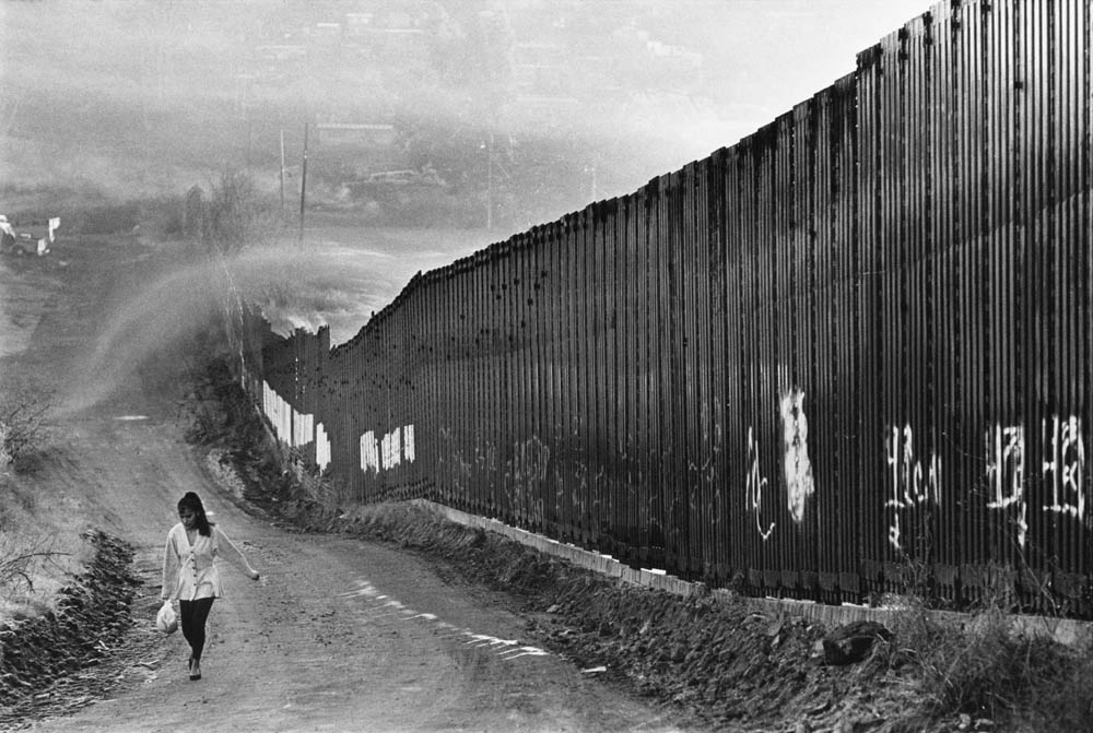 A woman walks on the U.S. side of the border as smoke pours over the wall from Nogales, Sonora. The smoke smelled of burning plastic. Photos by Jeffry D. Scott