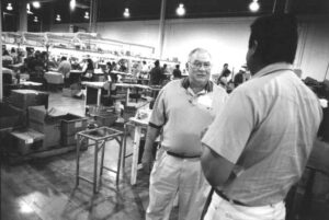 Tom Higgins, president of the S.L. Waber de Mexico plant in Nogales, Sonora, Mexico, talks with Industrial Engineer Francisco Javier Lopez on the plant floor.
