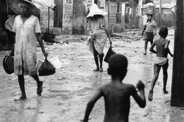 In the slums, people hurry home as the rains begin.