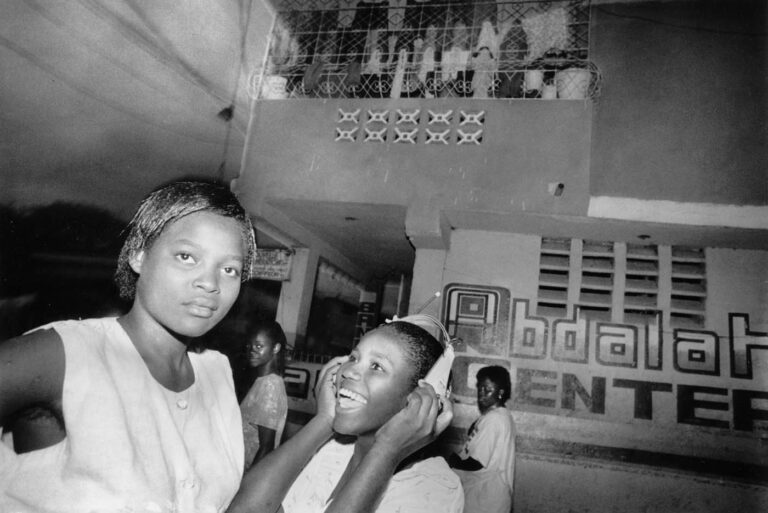 Teenagers listen to Haitian rap music on radio headsets sent by relatives from the States and Canada.
