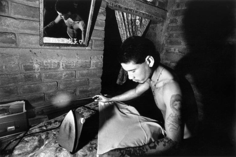 Edgar irons his shirt at his grandparents’ house. Tomorrow he plans to go to Metalio to get a copy of his birth certificate so that he can get his cedula, or identity card. With tattoos on his face and arms, he knows it will be hard to find work. Getting his papers is a first step.