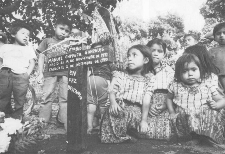 Children from a Guatemalan village honor the grave of a young, local man who died fighting for freedom.