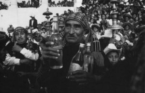 A villager holds three liquor bottles for use in the fiesta celebrations of the Guatemalan village of Todos Santos. He is a member of Cofradia, a religious brotherhood.