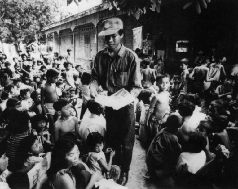 Employees from UNTAC pass out election information booklets in the Cambodian village of Tray Sla in April of 1993. Photo by Peter Charlesworth, JB Pictures
