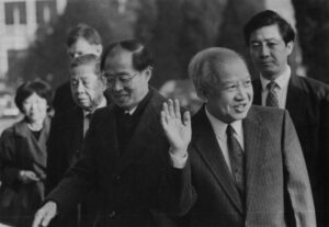 Cambodian Prince Norodom Shianouk, right, waves before entering a Supreme National Council Meeting in Beijing with Yasushi Akashi, left, the head of the U.N. peacekeeping operating in Cambodia. The meeting was held at Sihanouk's Beijing home. AP/Wide World Photos.