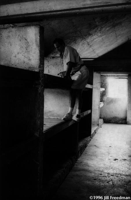 Ferber climbs on a shelf of one barrack in Birkenau, an industrial murder park where 1.5 million Jews were vaporized in three and a half years. Ten or more slept on each shelf. Ferber was born in Cracow, Poland and was first taken to the Plaszow camp, then Auschwitz, where he survived by organizing boys to pull garbage wagons. His brother died in Plaszow and his father was injected with gasoline on the last day of the war. He had survived until that very last day, but they just wouldn't let him live.
