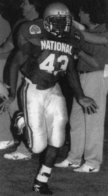 Saying his tackles are "high, mighty glory," Chamard Lauriston, a 6', 210-pound Haitian immigrant, was a star defensive back for Olympic Heights High School in Boca Raton, Florida in 1995. He is pictured in his final high school game. Lauriston's family emigrated from Haiti in the early 1980s. He was his high school's English student of the year and will attend Indiana State University in Terre Haute on a full football scholarship in September. He is the first of his clan to attend an American university. Photo by Jason Nuttle, The Palm Beach Post