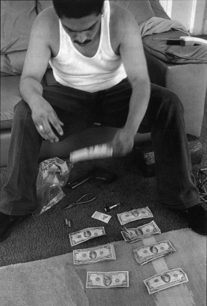 Chivo, who belongs to an east Los Angeles gang, counts his money the morning after a car-jacking. He stripped the car and sold the parts.