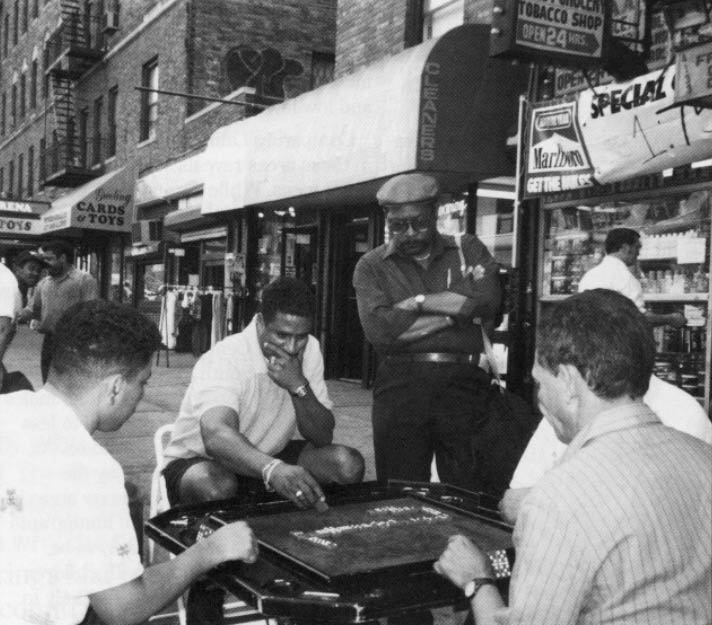 Residents play dominoes on boards set up on Washington Heights' sidewalks. Photo by APF Fellow Roberto Suro
