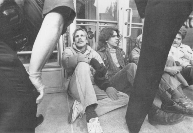AIDS activists chain themselves to a federal building in San Francisco to Protest government policies. The policemen are wearing rubber gloves.