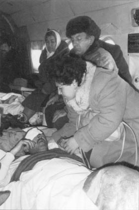 A woman from Karabakh holds the hand of her wounded husband on a helicopter flight back to Yerevan.