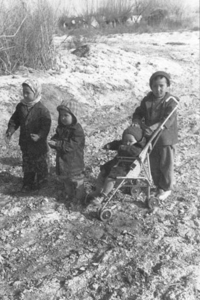 The children of Turehbai Telegenov and his wife play in the mix of silt and salt on their plot of land near Chimbai.
