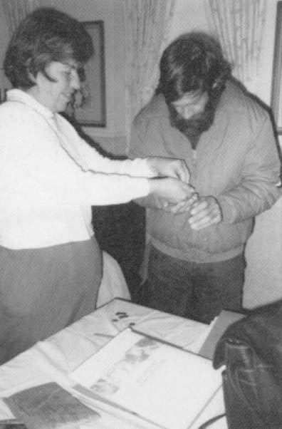 Nancy Cleaveland gives her boyfriend, Richard Carlson, dues that were collected at a People First meeting she led at the Southbury Training School. Photo by Rosalie Winard.