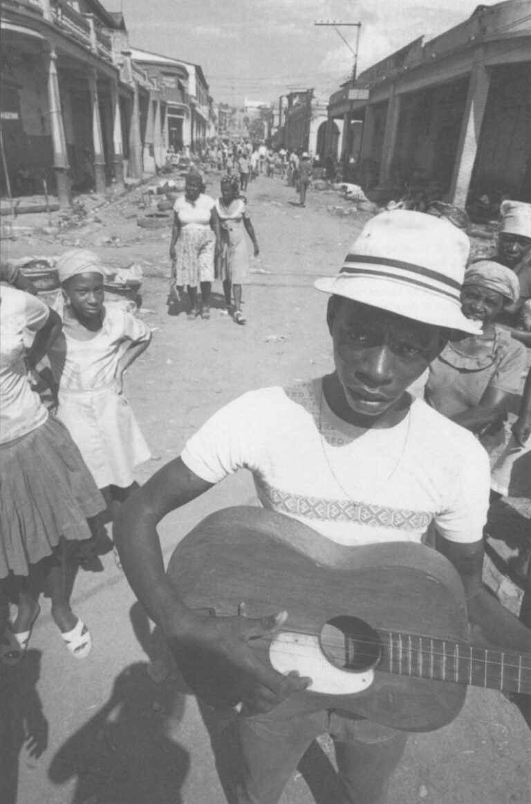A minstrel wanders the backstreets of Port-au-Prince, playing songs about wishes on a three-stringed guitar. He dreams, he says, of fame and a new guitar.