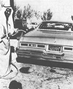 Arab putting gas in a car