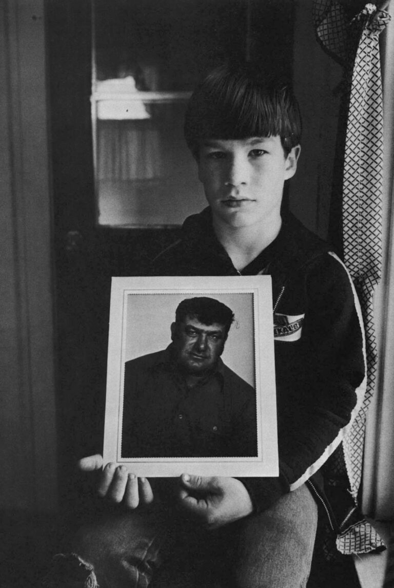 Joseph Fetter (9) of Chelsea holds a picture of his father, Phil. Mr. Fetter killed himself on July 25, 1982, knowing he was going to lose his farm.