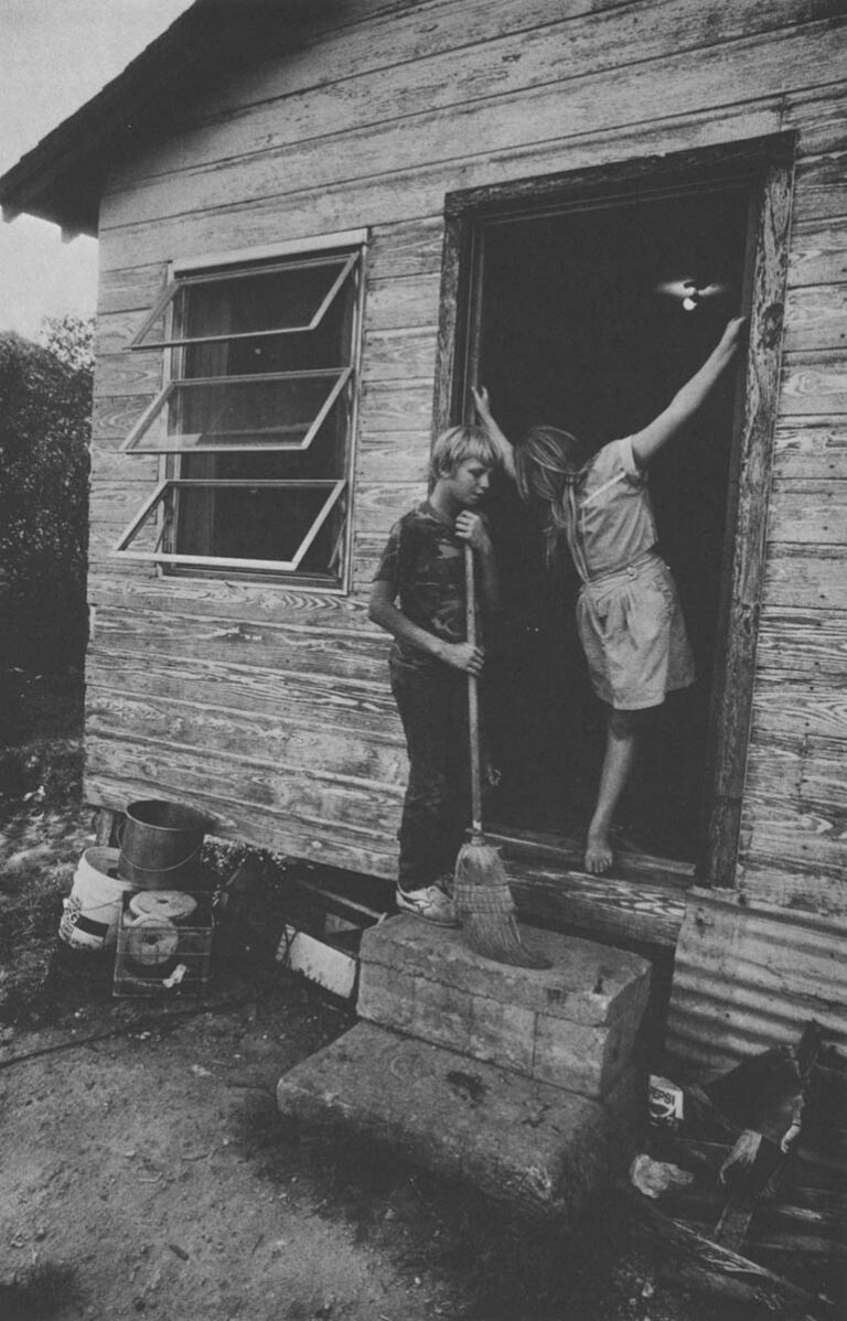 CLEWISTON, FLORIDA Ricky Summerall, 12 and his sister, Mary, 9, stand at the front door of their home. Their mother works full time as a short order cook.