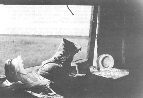 An abandoned Kansas farmhouse in late summer. All that remains are artifacts of a family that once called the dilapidated building home…an old work boot, an empty can of cashew nuts, the twist key from a can of sardines, a newspaper dated 1954 and the sounds of an unbroken wind filtering through the rusted screen.
