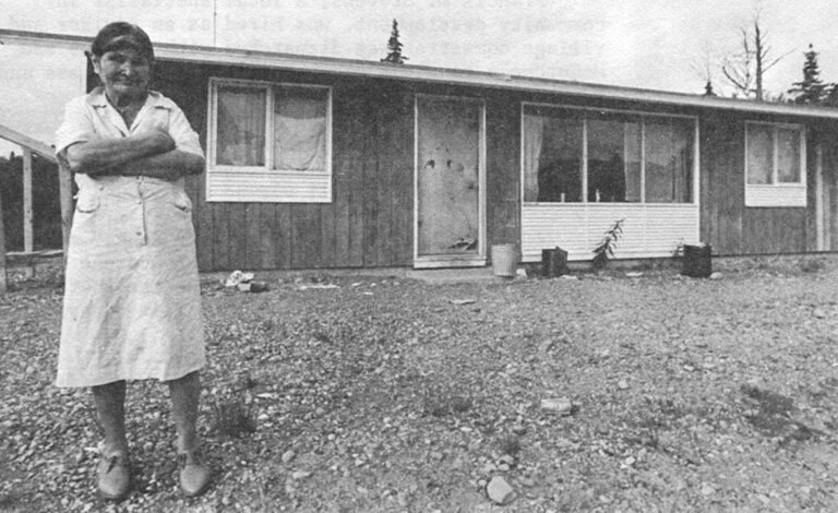 Lallie Chewitt – Tyonek native, surveys the morning in front of her modern home. Hers is a typical Tyonek dwelling.