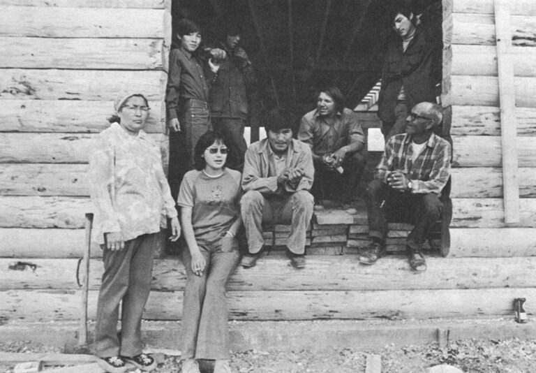 New Building –Sidney Huntington and part of his large family take a break from building their new house. They raised the rugged two story building in just eight days.