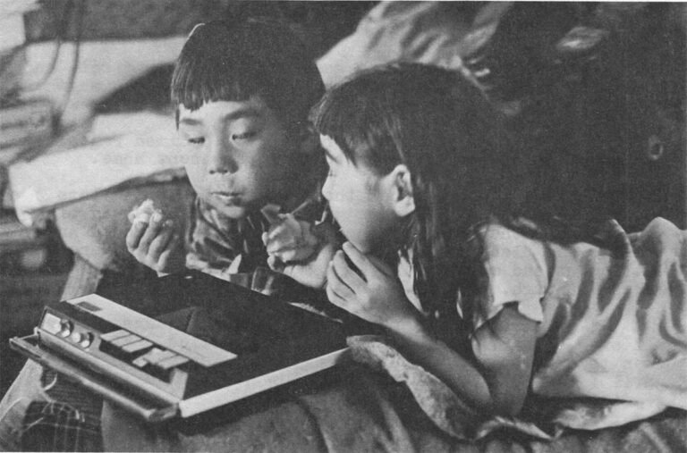 Anything New delights the Anaktuvuk youngsters. Above, Simon Paneak's son, Harold, and granddaughter, Vickey, check out the writer's cassette recorder which ia a newer model than Simon's. Below, a game of musical chairs at a school party.