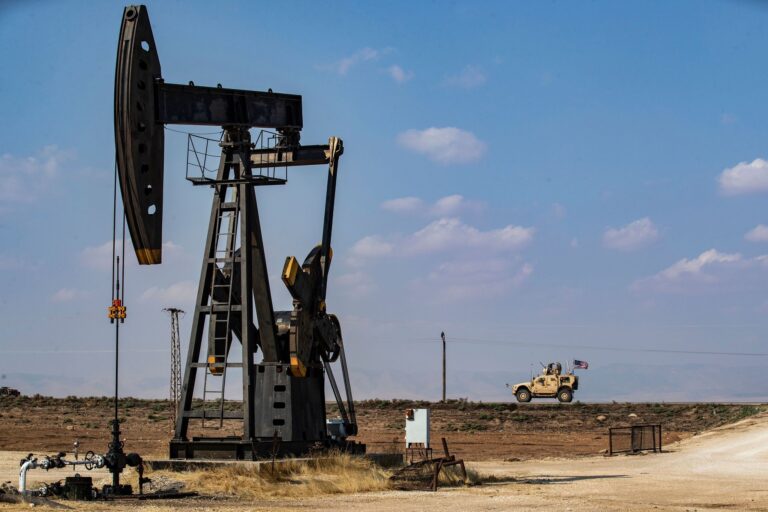 A US military vehicle, part of a convoy arriving from northern Iraq, drives past an oil pump jack in the countryside of Qamishli, in northeastern Syria. DELIL SOULEIMAN//Getty Images