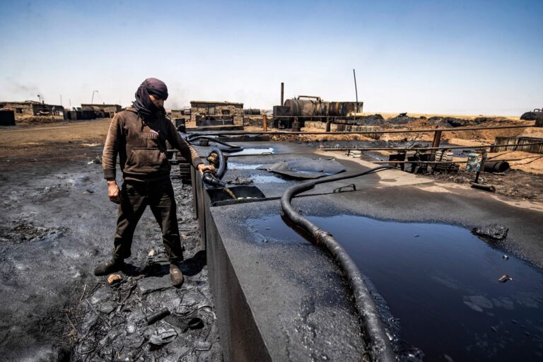 A man distills crude oil at a makeshift refinery near Rmelan, a major hub of Syria’s oil industry. until they were defeated, in 2019, isis occupiers funded their organization with profits from wells like these. DELIL SOULEIMAN//Getty Images