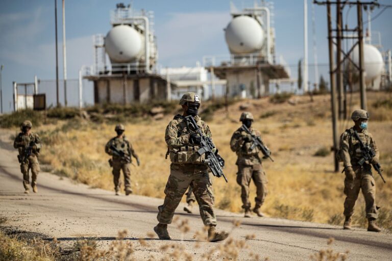 Mask-clad U.S. soldiers patrol near an oil production facility in northeastern Syria. DELIL SOULEIMAN//Getty Images