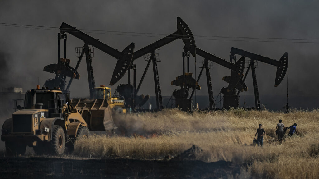 People battle a blaze next to an oil well in the Al-Hasakah province. DELIL SOULEIMAN//Getty Images